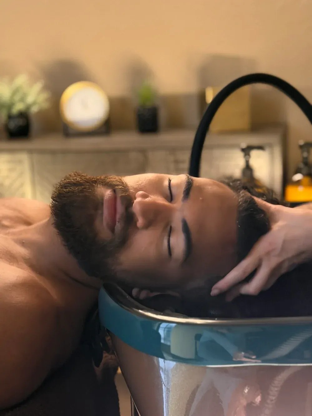A client relaxing during a scalp treatment at the MaRe basin