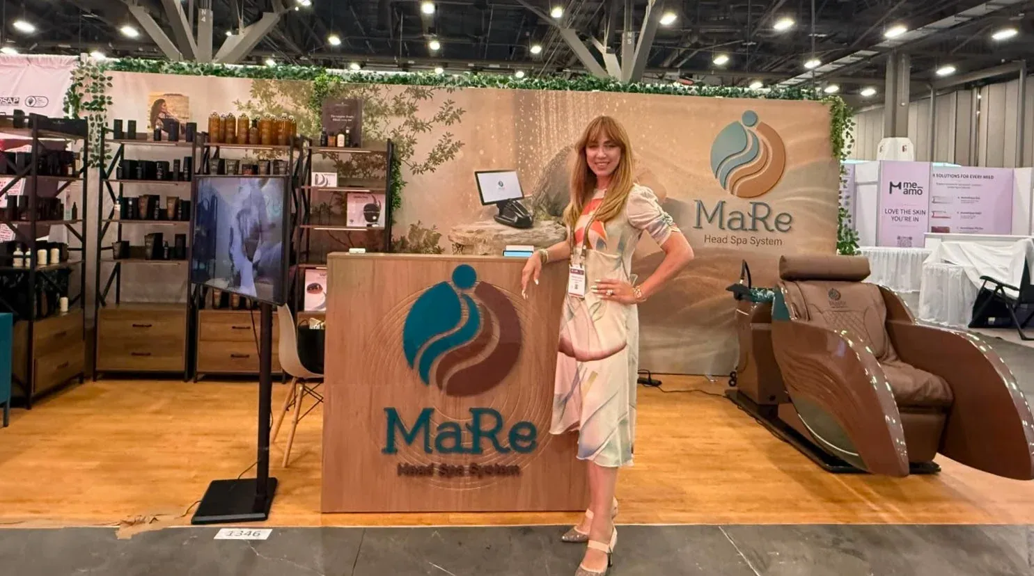 A MaRe team member at the MaRe Head Spa System exhibition stand next to the MaRe Capsule